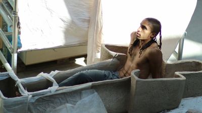 A photo of Ahmed Umar in a sarcophagus sculpture made in protest of queer oppression in his culture.